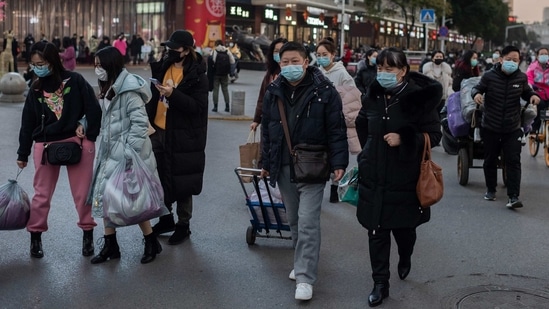People wearing face masks seen during a rush hour in Wuhan on January 13. The spike in new cases comes as a World Health Organization (WHO) team of experts investigating the origins of the pandemic is set to arrive on January 14 in Wuhan. The team will have to spend 14 days in quarantine, Reuters reported citing NHC spokesman Mi Feng.(Nicolas Asfouri / AFP)
