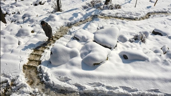 A boy walks climbs snow covered stairs after fresh snowfall at Tangmarg in Baramulla district of north Kashmir, late in December, 2020. (File photo)