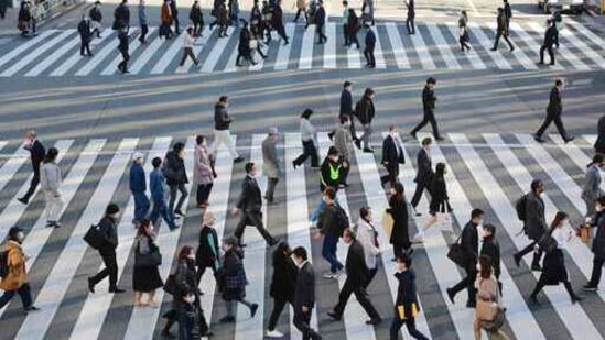People wearing face masks to protect against the spread of the coronavirus cross an intersection on a street in Tokyo. (AP) People wearing face masks to protect against the spread of the coronavirus cross an intersection on a street in Tokyo. (AP)