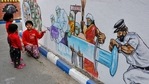Kolkata: Children look at a mural depicting frontline workers fighting against COVID-19, at Brahmahapur in Kolkata, (PTI) Kolkata: Children look at a mural depicting frontline workers fighting against COVID-19, at Brahmahapur in Kolkata, (PTI)
