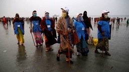 Workers from a village council wearing face shields patrol at the confluence of the river Ganga and the Bay of Bengal on the occasion of Makar Sankranti festival at Sagar Island, in West Bengal, on January 14. India’s tally of cases of the coronavirus disease (Covid-19) crossed the 10.5 million mark the Union health ministry announced on January 14.