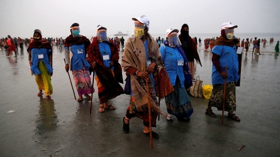 Workers from a village council wearing face shields patrol at the confluence of the river Ganga and the Bay of Bengal on the occasion of Makar Sankranti festival at Sagar Island, in West Bengal, on January 14. India’s tally of cases of the coronavirus disease (Covid-19) crossed the 10.5 million mark the Union health ministry announced on January 14.(Rupak De Chowdhuri/REUTERS)