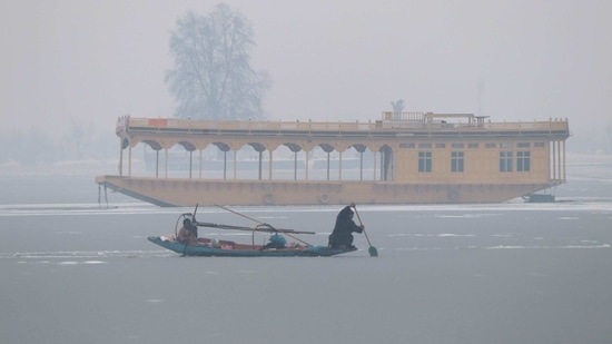A Kashmiri boatman uses an oar to break the ice layer waters of Dal Lake after a snowfall, in Srinagar on Sunday. (ANI Photo) A Kashmiri boatman uses an oar to break the ice layer waters of Dal Lake after a snowfall, in Srinagar on Sunday. (ANI Photo)