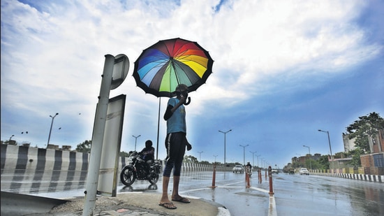 A man uses an umbrella to take shade from the rain in New Delhi on June 25, 2020 during the Covid lockdown. (Raj K Raj/HT PHOTO) A man uses an umbrella to take shade from the rain in New Delhi on June 25, 2020 during the Covid lockdown. (Raj K Raj/HT PHOTO)
