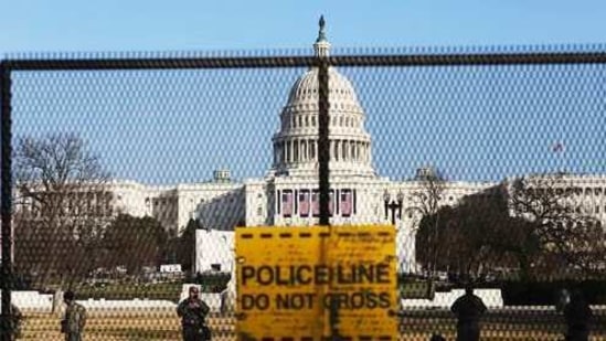 National guards are seen Wednesday, Jan. 13, 2021 on a fence that was erected to reinforce security at the Capitol in Washington. (AP) National guards are seen Wednesday, Jan. 13, 2021 on a fence that was erected to reinforce security at the Capitol in Washington. (AP)