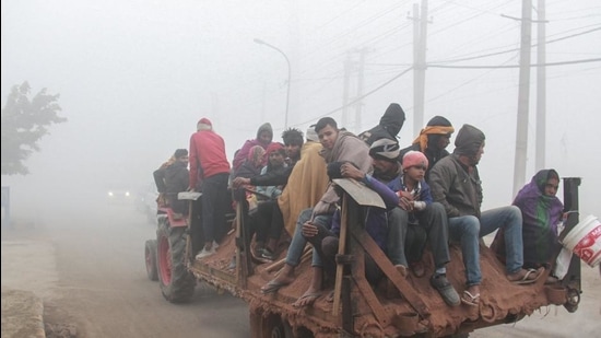 People travel on a tractor trolly amid low visibility due to dense fog, in Gurugram on January 13. (PTI) People travel on a tractor trolly amid low visibility due to dense fog, in Gurugram on January 13. (PTI)
