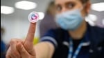 A member of the medical team holds up a sticker reading A member of the medical team holds up a sticker reading