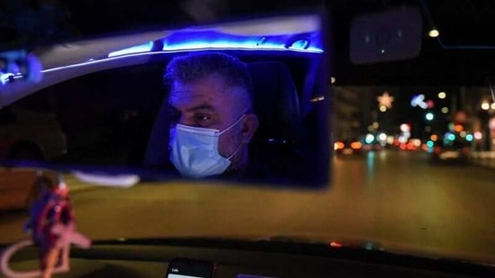Konstantinos Bekios, who has turned his taxi into a 'night club', is reflected in the rear view mirror while driving, amid the coronavirus disease (COVID-19) pandemic, in Thessaloniki, Greece, January 14, 2021.(Reuters)