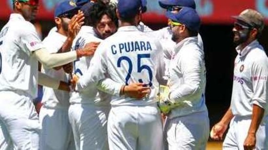 Indian players congratulate teammate Mohammed Siraj, centre, after dismissing Australia's David Warner during first day of the fourth cricket test between India and Australia at the Gabba, Brisbane. (AP) Indian players congratulate teammate Mohammed Siraj, centre, after dismissing Australia's David Warner during first day of the fourth cricket test between India and Australia at the Gabba, Brisbane. (AP)
