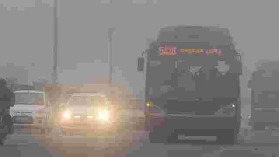 Traffic moves slowly through a dense fog in New Delhi. Cold wave conditions continued across North India claiming 165 lives this winter. AFP PHOTO / Prakash Singh Traffic moves slowly through a dense fog in New Delhi. Cold wave conditions continued across North India claiming 165 lives this winter. AFP PHOTO / Prakash Singh