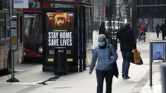 A coronavirus information sign is displayed by a bus stop in London. (AP Photo)