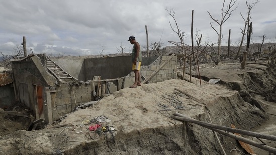 Fisherman Rogelito Cacao looks at the remains of his house at the Taal volcano on January 10. Cacao regularly visits his home on the volcanic island south of the Philippine capital. “I miss our belongings but it is now covered in ash, our livestock like our cow, our horse, our pig, our boat and engines are all covered by the volcano, these are what I miss,” he told AP.(Aaron Favila / AP)