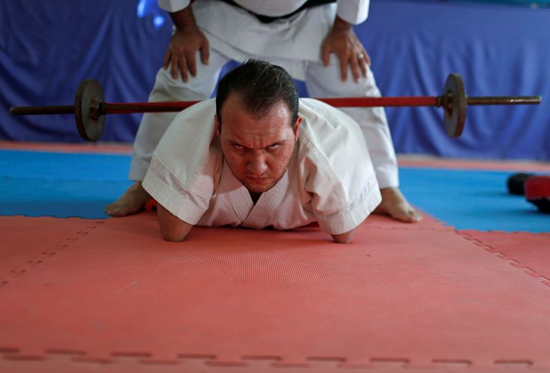 Youssef Abu Amira lifts weights as he practices Karate. (REUTERS)