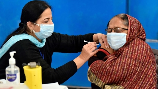 A health worker administers the Covishield vaccine to a woman at a vaccine delivery site in Gurugram on January 16. On the first day, around 300,000 people were set to be vaccinated at 3,000 centres. About 150,000 staff in 700 districts have been trained to administer jabs and keep records.(Sanjeev Verma / HT Photo)