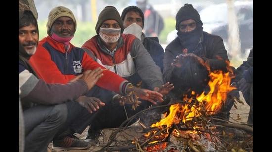 A group of men warming their hands over a bonfire at the Sector 20-21 roundabout in Chandigarh on Saturday. (Keshav Singh/HT) A group of men warming their hands over a bonfire at the Sector 20-21 roundabout in Chandigarh on Saturday. (Keshav Singh/HT)