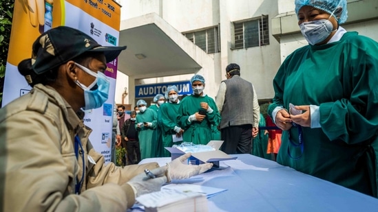 Medical workers wait to be inoculated with a Covid-19 vaccine at a hospital in New Delhi on January 16. The inoculation of the health workers will be followed by about 270 million people who fall in this high-risk category because they are older than 50 or deemed high-risk because of pre-existing medical conditions.( Jewel Samad / AFP)