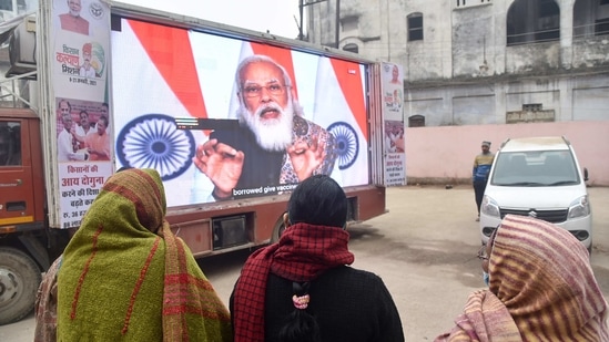 People watch the live telecast of Prime Minister Narendra Modi addressing the nation on the launch of Covid -19 vaccination drive, at District Hospital in Varanasi, Saturday, Jan. 16, 2021.(PTI) People watch the live telecast of Prime Minister Narendra Modi addressing the nation on the launch of Covid -19 vaccination drive, at District Hospital in Varanasi, Saturday, Jan. 16, 2021.(PTI)
