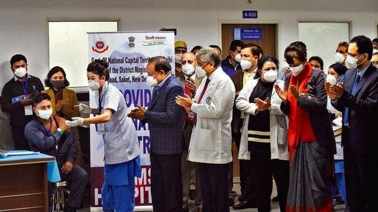 Sanitiation worker Manish Kumar was the first person in the Capital to be administered a Covid-19 jab as Union health minister Dr Harsh Vardhan and Dr Randeep Guleria look on at AIIMS on Saturday.(Amal KS/HT PHOTO) Sanitiation worker Manish Kumar was the first person in the Capital to be administered a Covid-19 jab as Union health minister Dr Harsh Vardhan and Dr Randeep Guleria look on at AIIMS on Saturday.(Amal KS/HT PHOTO)