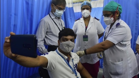 A BMC medical staffer takes a selfie while receiving the a Covid-19 vaccine shot at KEM Hospital. (Anshuman Poyrekar/HT Photo)