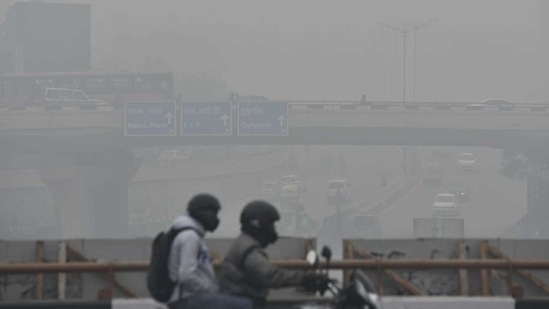 Commuters on their way during cold and foggy morning in New Delhi, India. (HT photo/ Sanjeev Verma)