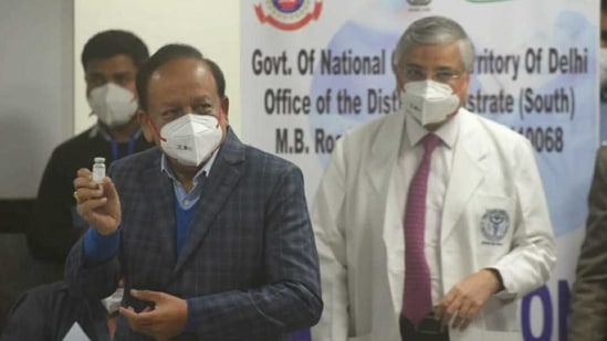 Union minister health minister Harsh Vardhan along with AIIMS director shows vaccine during the vaccination process at AIIMS Hospital in New Delhi (HT Photo/ Amal KS)