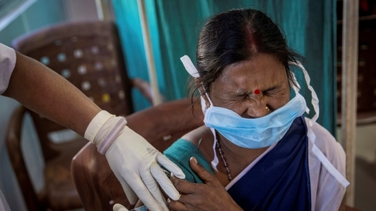 A healthcare worker reacts as she receives a dose of Covid-19 vaccine.(Reuters)