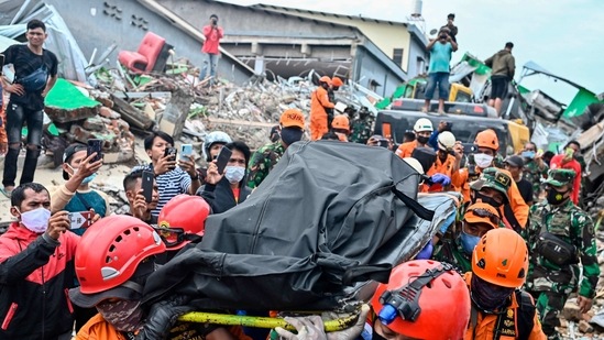 Rescuers move the body of a victim that was trapped in a collapsed building in Mamuju a day after a 6.2-magnitude earthquake rocked Indonesia's Sulawesi island. (AP) Rescuers move the body of a victim that was trapped in a collapsed building in Mamuju a day after a 6.2-magnitude earthquake rocked Indonesia's Sulawesi island. (AP)