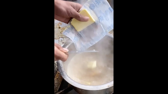The image shows an individual cutting a brick of butter.(Instagram/@foodieagraaaaa)