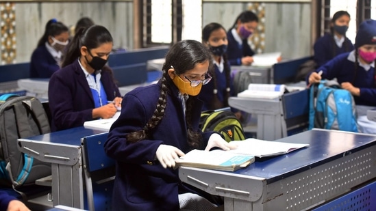 A student wearing a face mask and protective gloves attends a class at Govt Sarvodaya Girls Senior Secondary School in West Vinod Nagar on January 18. After a closure of 10 months due to the Covid-19 pandemic, students of classes 10 and 12 returned to Delhi’s public schools on January 18 for practical lessons, counselling, and doubt-clearing sessions.(Raj K Raj / HT Photo)