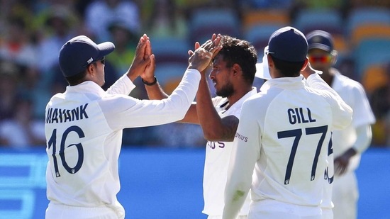 India's Thangarasu Natarajan, centre, is congratulated by teammates after dismissing of Australia's Marnus Labuschagne during play on the first day of the fourth cricket test between India and Australia at the Gabba, Brisbane, Australia, Friday, Jan. 15, 2021. (AP Photo/Tertius Pickard) (AP)