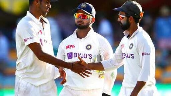 India's Washington Sundar is congratulated by his captain Ajinkya Rahane, right, as Rishabh Pant, centre, watches following play on the first day of the fourth cricket test between India and Australia at the Gabba, Brisbane, Australia, Friday, Jan. 15, 2021. (AP Photo/Tertius Pickard) (AP)