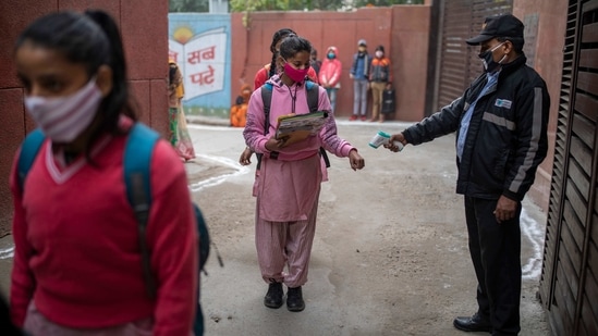 A student is thermal screened before entering a school in New Delhi on January 18. The government has made clear that physical attendance is not compulsory and students will attend schools only with the consent of parents.(Altaf Qadri / AP)