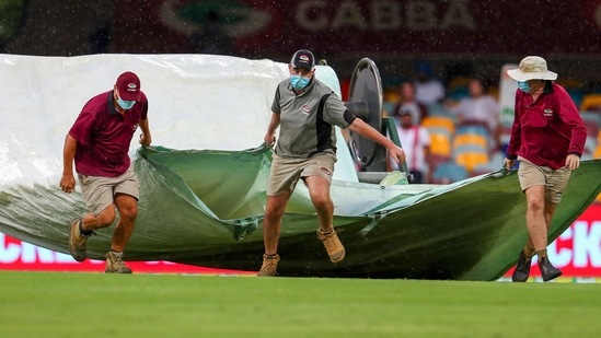 Brisbane: Ground staff bring covers onto the field as the rain stops play on day four of the fourth cricket Test between India and Australia at the Gabba, Brisbane(AP) Brisbane: Ground staff bring covers onto the field as the rain stops play on day four of the fourth cricket Test between India and Australia at the Gabba, Brisbane(AP)
