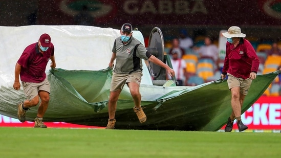 Brisbane: Ground staff bring covers onto the field as rain stops play on day four of the fourth cricket test between India and Australia at the Gabba, Brisbane, Australia, Monday, Jan. 18, 2021. AP/PTI(AP01_18_2021_000076A)(AP) Brisbane: Ground staff bring covers onto the field as rain stops play on day four of the fourth cricket test between India and Australia at the Gabba, Brisbane, Australia, Monday, Jan. 18, 2021. AP/PTI(AP01_18_2021_000076A)(AP)