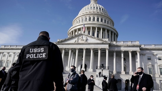 High-level security officials make a survey of the East Front of the Capitol after an announcement of security problems during inauguration rehearsal.(AP)