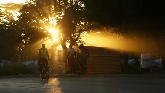 The sun sets as a man cycles home at the end of the day in Harare, Zimbabwe, (AP) The sun sets as a man cycles home at the end of the day in Harare, Zimbabwe, (AP)