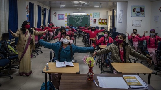School students gesture during a class, in New Delhi on January 18. The Delhi government has only allowed schools outside Covid-19 containment zones to reopen as of now.(Altaf Qadri / AP )