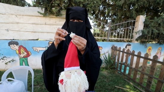 A Palestinian woman wearing face veil, niqab, works on a Christmas-themed doll in a handicraft workshop. (Representational Image / REUTERS)