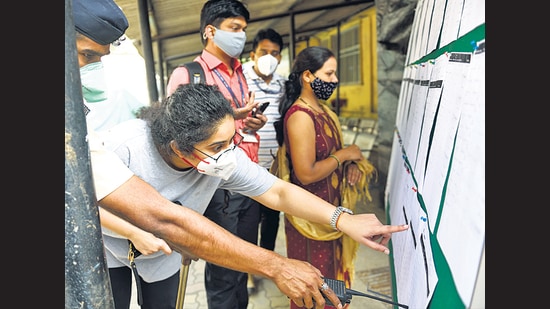 Healthcare workers check the details on the notice board before the vaccination process at Rajawadi Hospital on Tuesday. (Satish Bate/HT Photo) Healthcare workers check the details on the notice board before the vaccination process at Rajawadi Hospital on Tuesday. (Satish Bate/HT Photo)