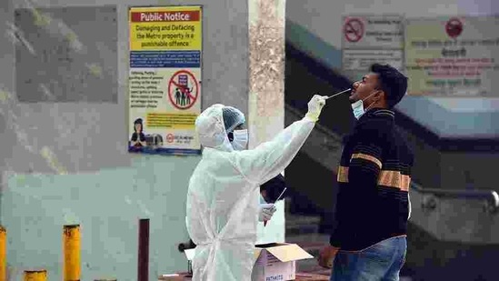 A health worker in PPE collects a swab sample from a person for coronavirus testing, outside New Ashok Nagar Metro station in New Delhi.(Raj K Raj/HT PHOTO) A health worker in PPE collects a swab sample from a person for coronavirus testing, outside New Ashok Nagar Metro station in New Delhi.(Raj K Raj/HT PHOTO)