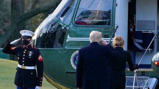 President Donald Trump salutes as he boards Marine One with First Lady Melania Trump on the South Lawn of the White House in Washington.(AP)