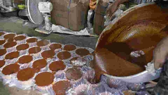 Rahim pours in warm jaggery into moulds where it hardens --the final step before it is ready to be sold. The workers have shown concerns that post demonetization they weren’t able to make profits but they hope this once go-to sweetener in Indian cooking will also lend itself to this year’s earnings. (Diptendu Dutta / AFP)