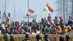 Farmers hold flags as police personnel stand guard behind barricades during protests against new farm laws at Ghazipur (Delhi-UP border). (Sakib Ali / HT Photo) Farmers hold flags as police personnel stand guard behind barricades during protests against new farm laws at Ghazipur (Delhi-UP border). (Sakib Ali / HT Photo)