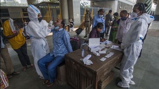 A healthcare worker collects the swab sample of a passenger at Dadar station on Thursday. (Pratik Chorge/HT Photo) A healthcare worker collects the swab sample of a passenger at Dadar station on Thursday. (Pratik Chorge/HT Photo)