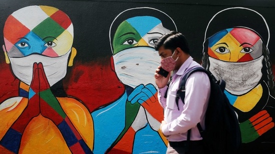 A man walks past graffiti of people wearing protective masks amidst the spread of the coronavirus disease (Covid-19) on a street in Navi Mumbai, on January 21. India recorded 15,223 new cases of the coronavirus disease (Covid-19) in the last 24 hours, according to Union health ministry update. With this, the nationwide tally reached 10,610,883.( Francis Mascarenhas / REUTERS)