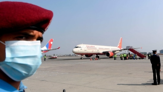 A policeman watches as an aircraft from India carrying Covishield, AstraZeneca-Oxford's Covid-19 coronavirus vaccine made by India's Serum Institute arrives at the Tribhuvan International Airport in Kathmandu on January 21, 2021.(AFP) A policeman watches as an aircraft from India carrying Covishield, AstraZeneca-Oxford's Covid-19 coronavirus vaccine made by India's Serum Institute arrives at the Tribhuvan International Airport in Kathmandu on January 21, 2021.(AFP)