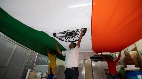 Workers inspecting a large Indian tricolour after stitching it ahead of Republic Day. (HT Photo)