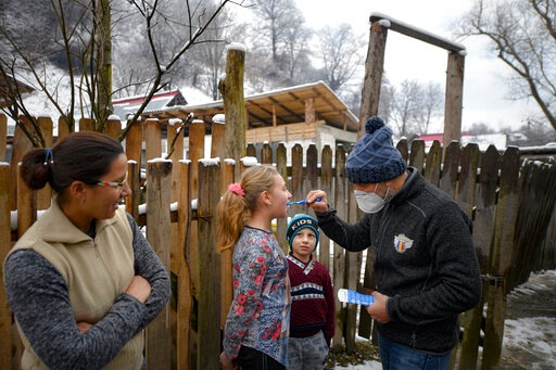A little boy watches Valeriu Nicolae showing a girl how to correctly brush her teeth.(AP) A little boy watches Valeriu Nicolae showing a girl how to correctly brush her teeth.(AP)