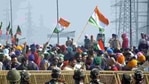 Farmers hold flags as police personnel stand guard behind barricades during protests against new farm laws at Ghazipur (Delhi-UP border) (Sakib Ali / HT Photo). Farmers hold flags as police personnel stand guard behind barricades during protests against new farm laws at Ghazipur (Delhi-UP border) (Sakib Ali / HT Photo).