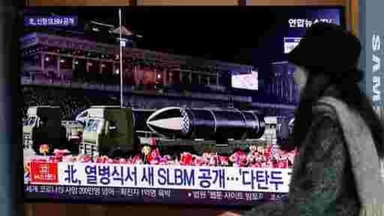 A woman wearing a face mask walks past in front of a TV screen showing a news program reporting about North Korea's military parade, at the Seoul Railway Station in Seoul, South Korea, Friday, Jan. 15, 2021. North Korea rolled out developmental ballistic missiles designed to be launched from submarines and other military hardware in a parade that punctuated leader Kim Jong Un's defiant calls to expand his nuclear weapons program. The part of letters read "North, new SLBM during a military parade." (AP Photo/Lee Jin-man)(AP)